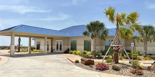 Image 4: Modern single-story home with a blue metal roof, c