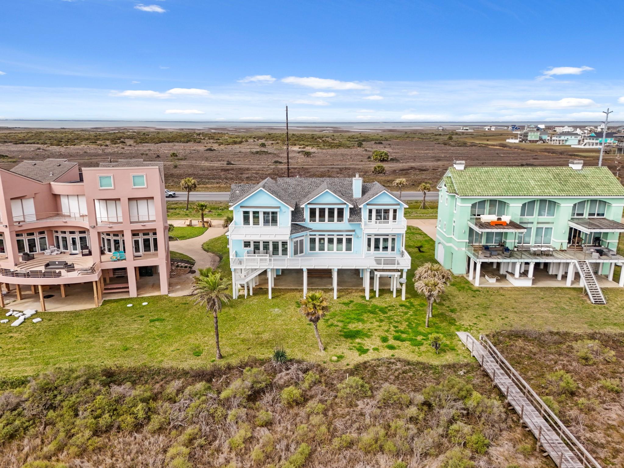 Image 2: Rear exterior of the home shows a large lot with a