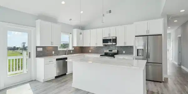 Image 3: Modern kitchen featuring white cabinetry, a large