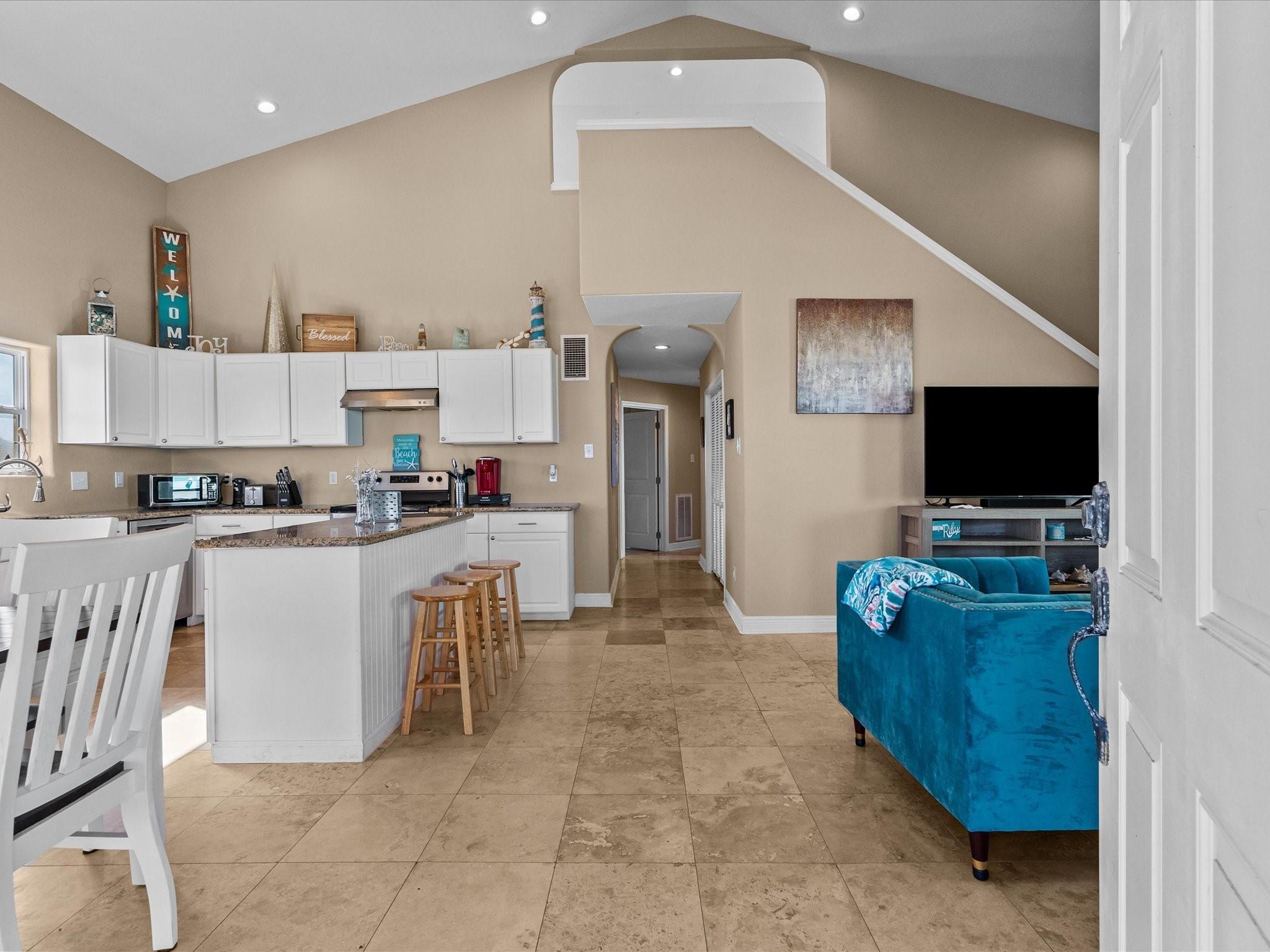 Image 4: This open-concept living area features high ceilin
