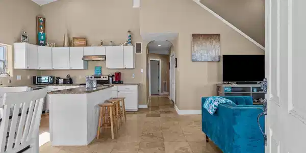 Image 4: This open-concept living area features high ceilin