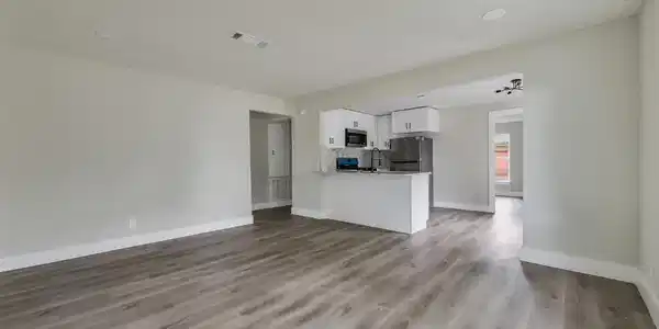 Image 4: Spacious open living area with updated flooring an