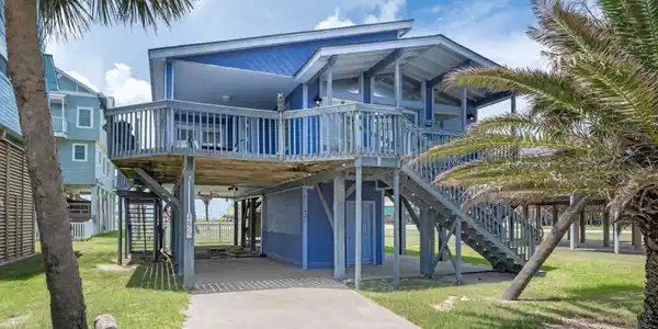 Image 2: Elevated coastal home with an inviting covered fro
