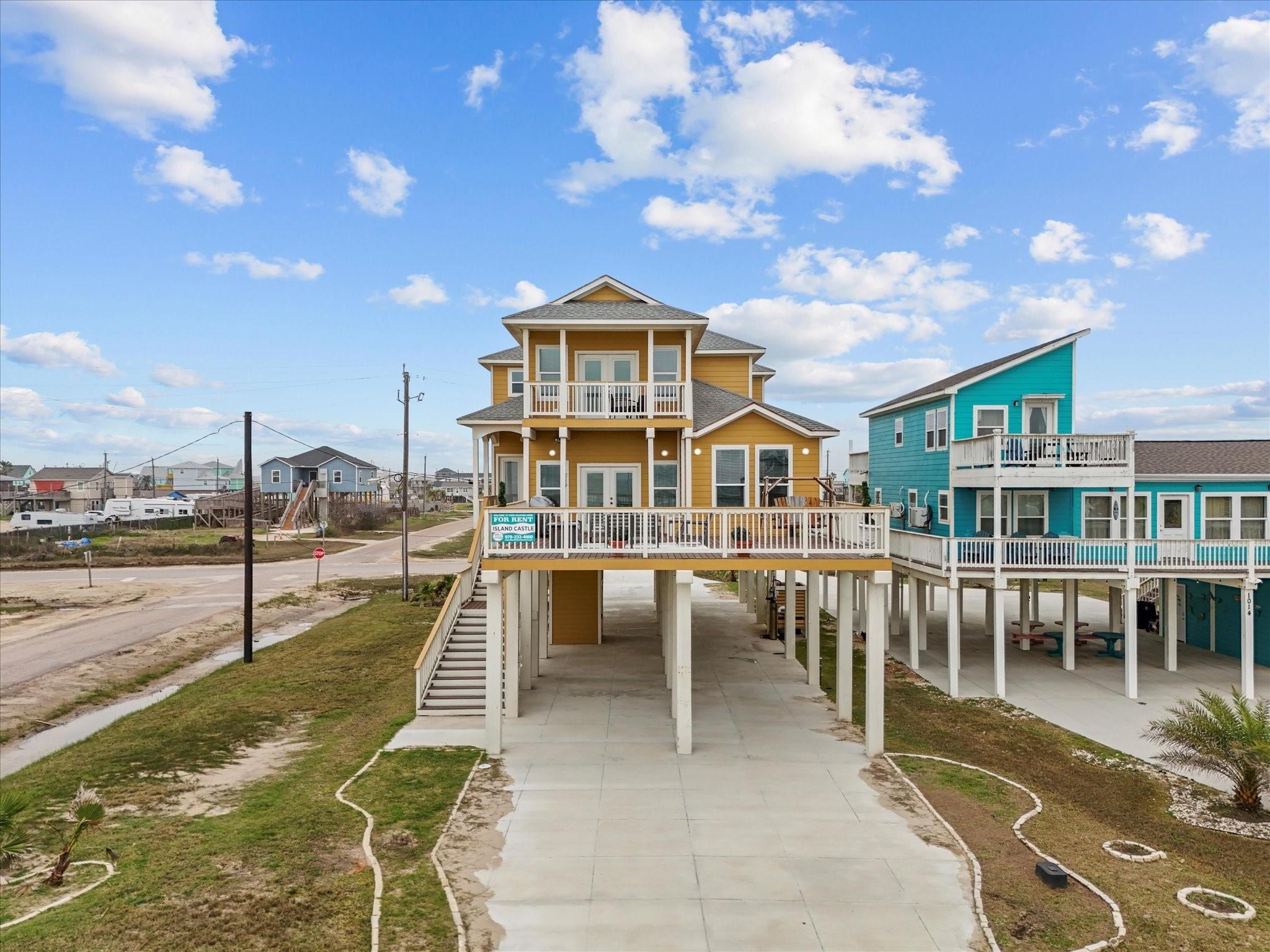 Image 2: This photo shows a vibrant, elevated beach house w