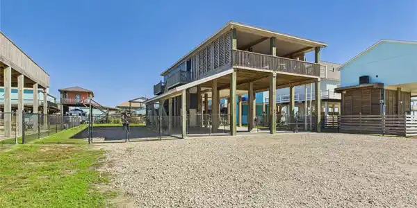 Image 3: Elevated beach-style home with a spacious wrap-aro