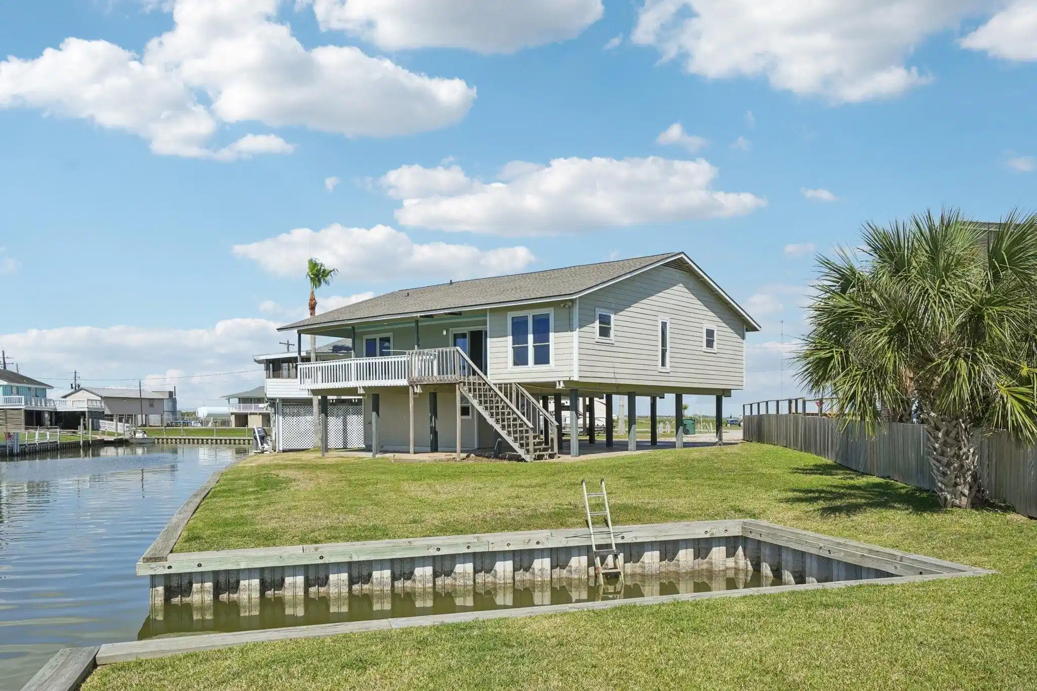 Image 1: This waterfront home features a spacious deck over