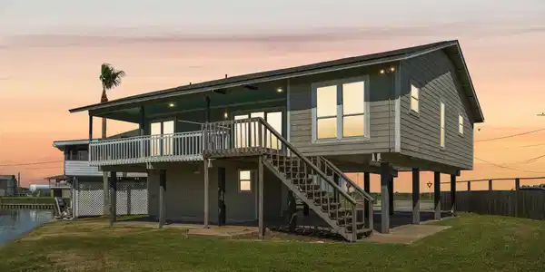 Image 2: This elevated coastal home features a spacious dec