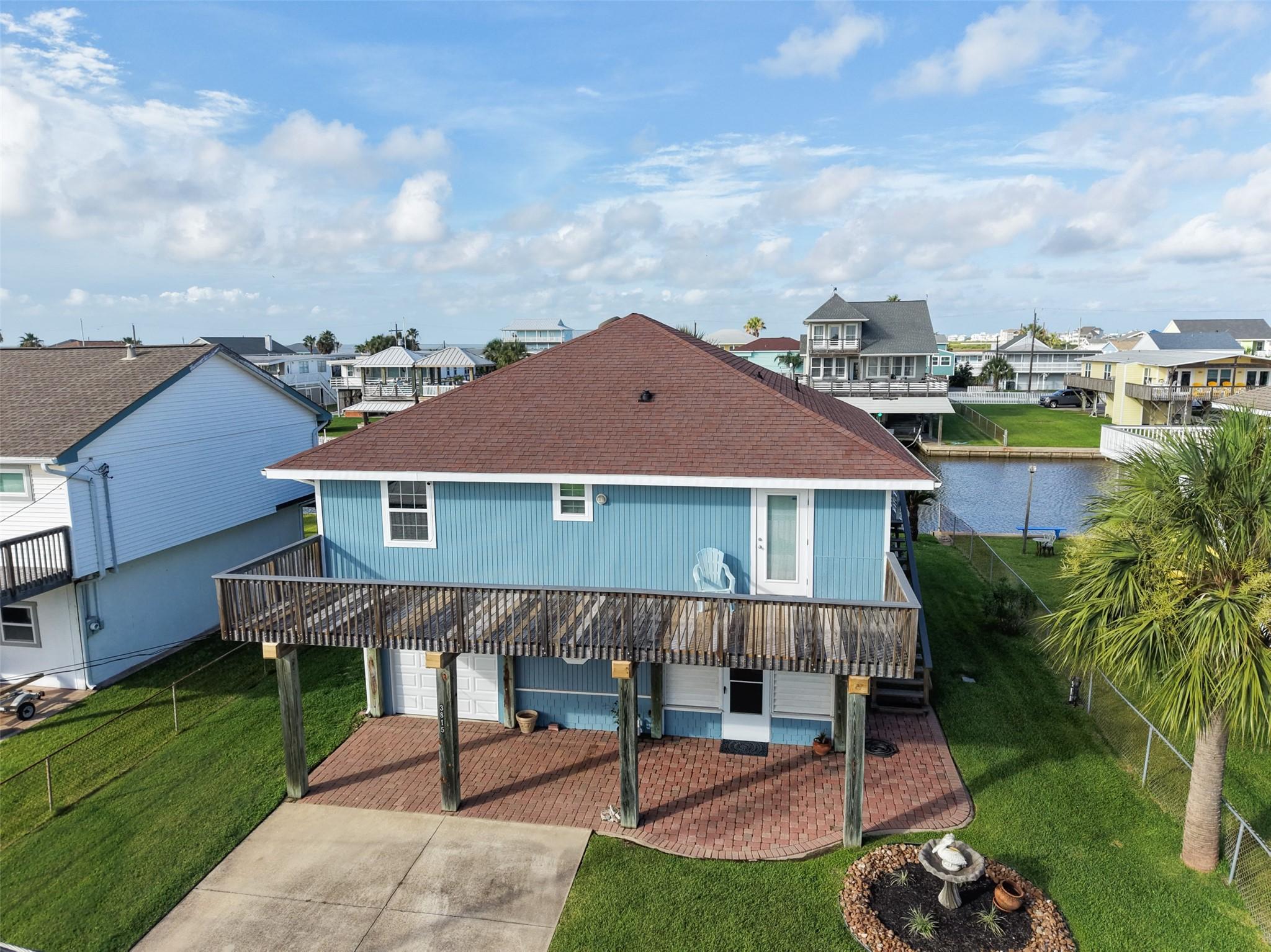 Image 2: This elevated coastal home features a charming blu
