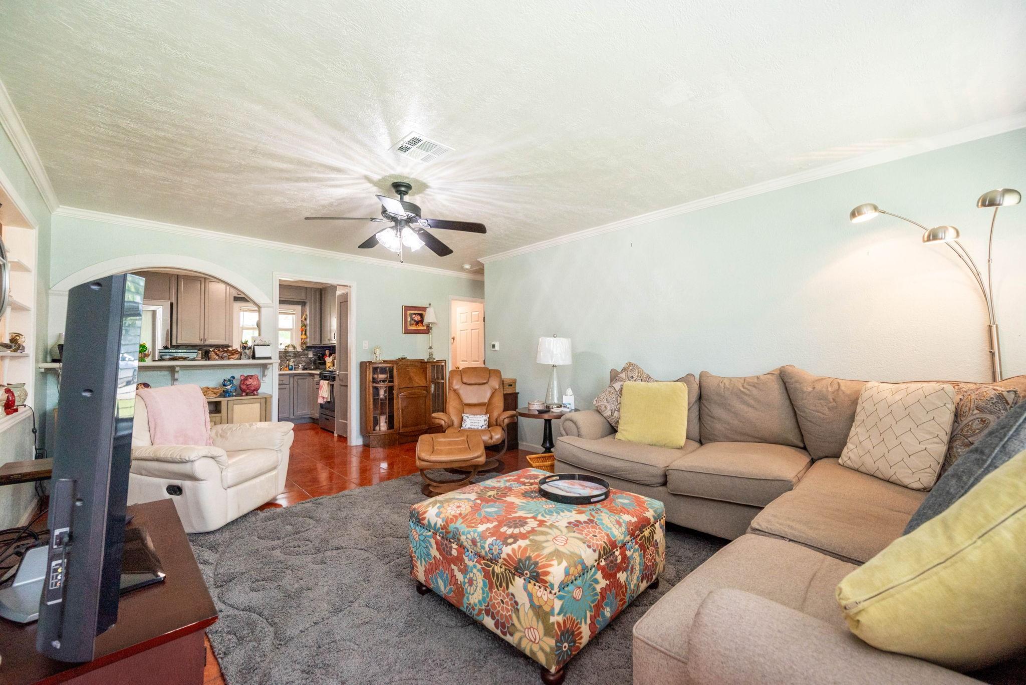 Image 3: Spacious living room with soft pastel walls. Open