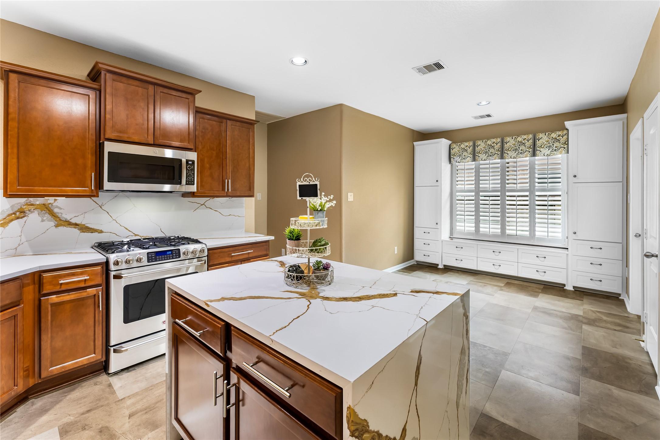 Image 2: Modern kitchen featuring warm wood cabinetry, eleg