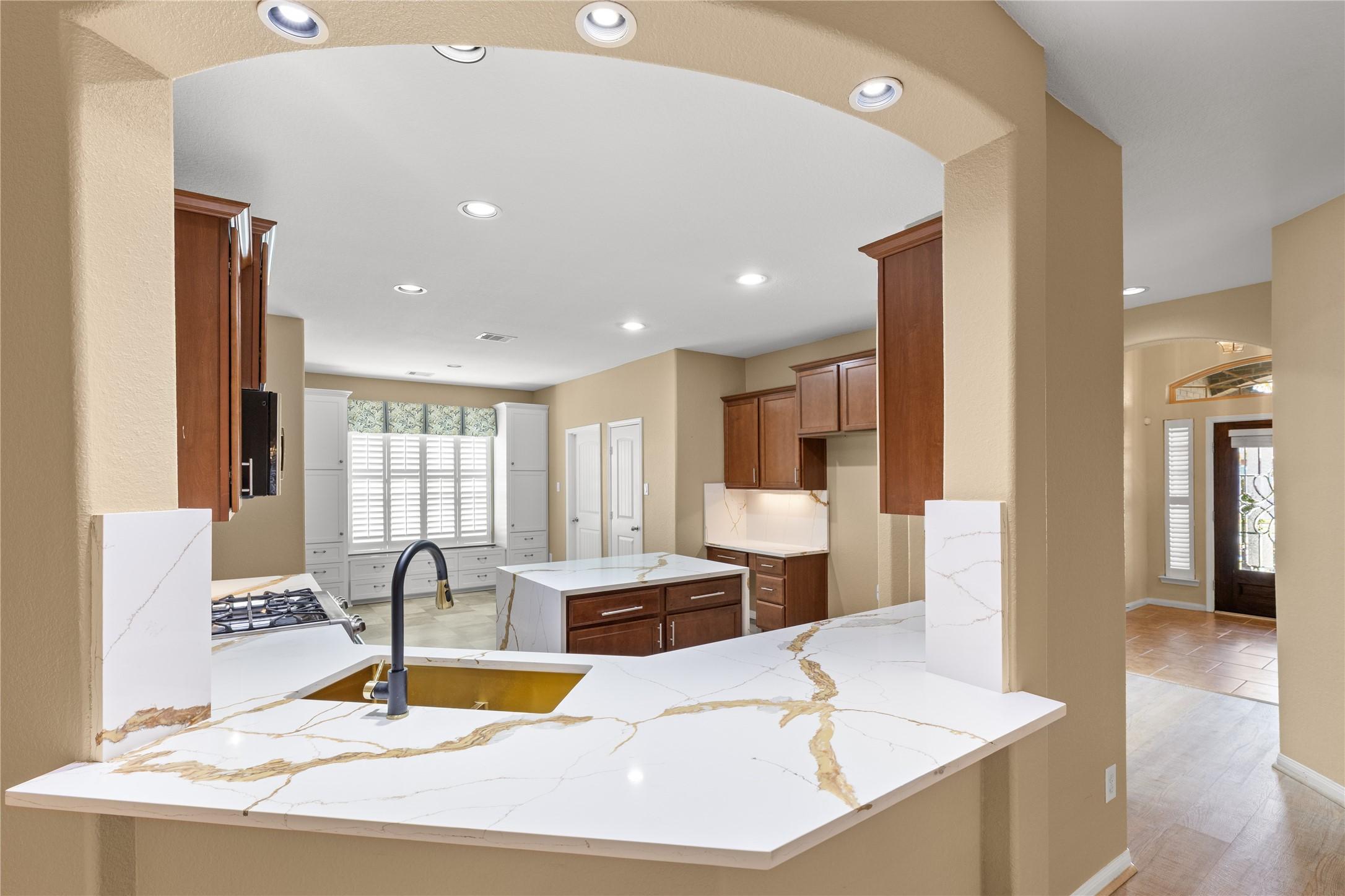 Image 3: This kitchen features elegant marble countertops,