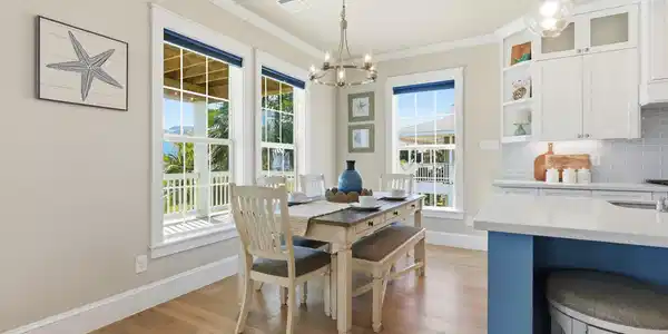 Image 4: Bright dining area with large windows, a wooden ta