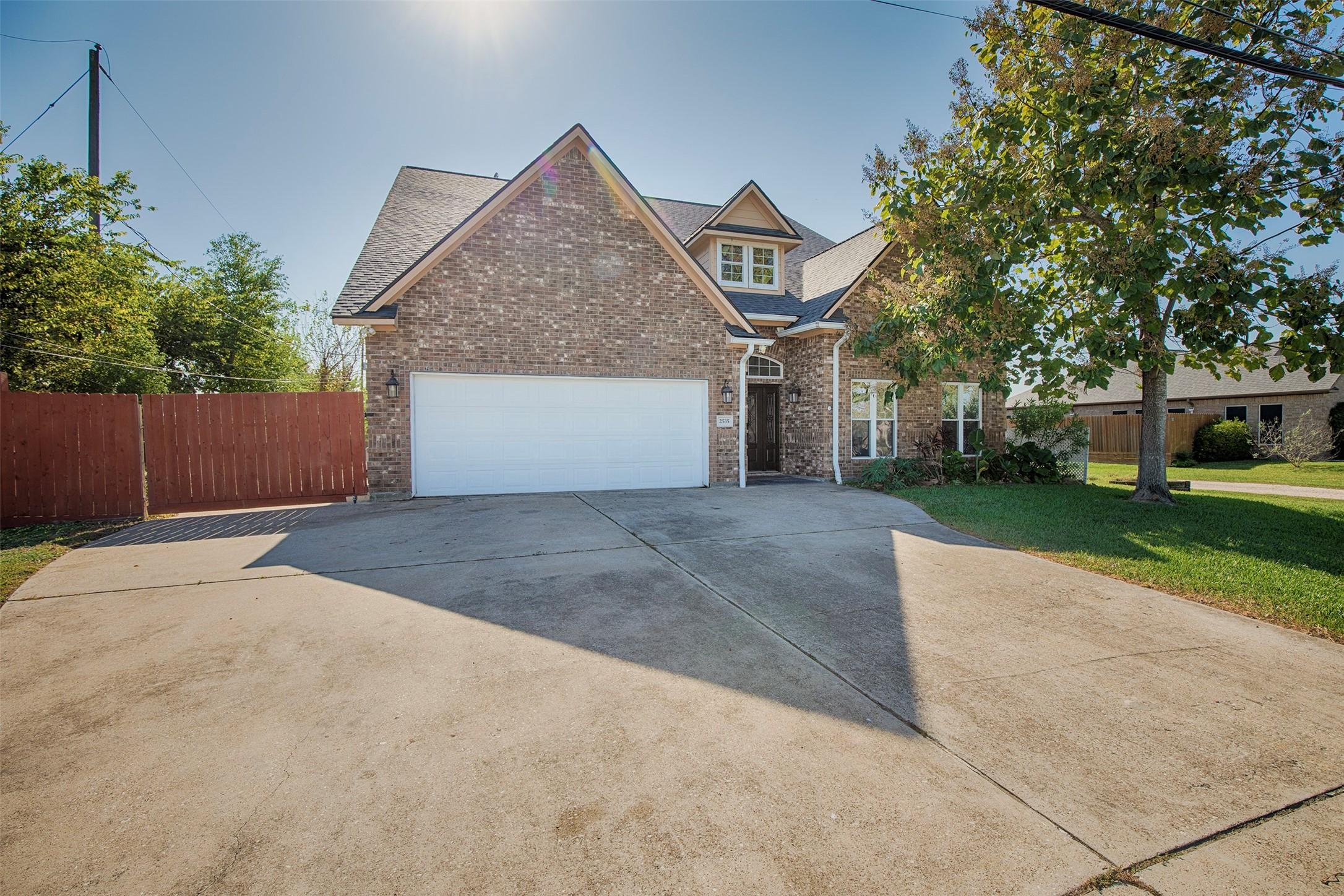 Image 2: The home has ample parking space and a large gated