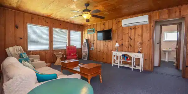 Image 3: This cozy living room features warm wood paneling,