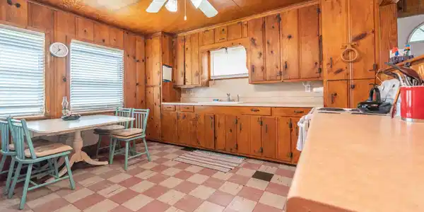 Image 4: A cozy kitchen featuring warm wood paneling and ca