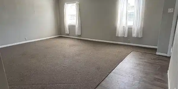 Image 3: This spacious room features a mix of carpet and wo