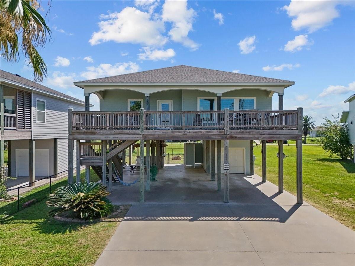 Image 2: This elevated home features an expansive deck, ide