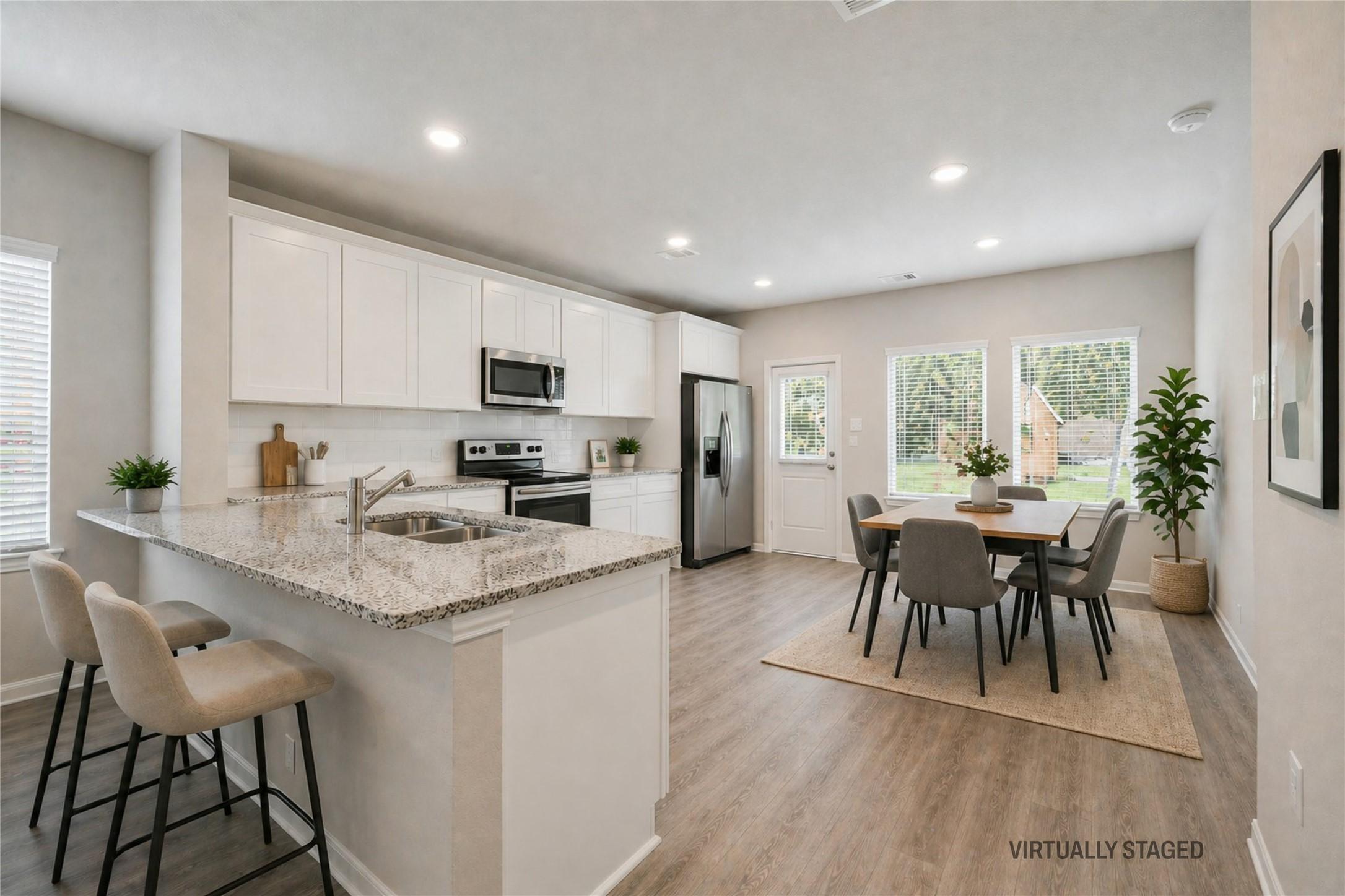 Image 4: Virtually staged photo of breakfast bar and kitche