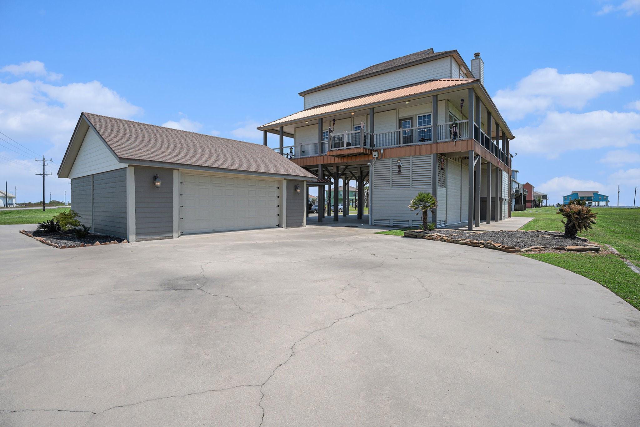 Image 2: A generous driveway and detached garage are promin