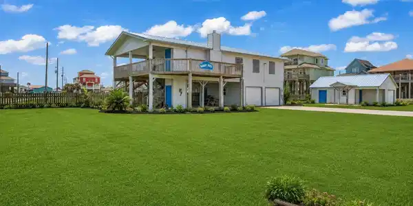 Image 4: The wide lot includes a large grass lawn, the main