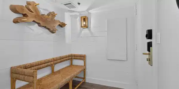 Image 4: The entryway with white shiplap walls, &nbsp;woven benc