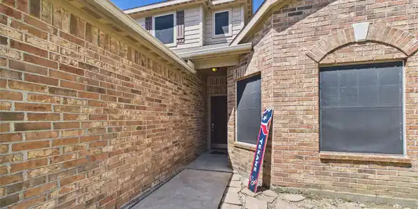 Image 3: Charming brick exterior with a welcoming walkway l