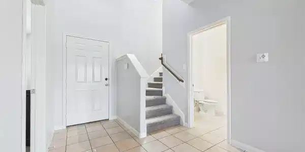 Image 4: Bright entryway with tiled flooring and a new carp