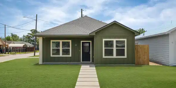 Image 2: Charming single-story home with a modern green ext