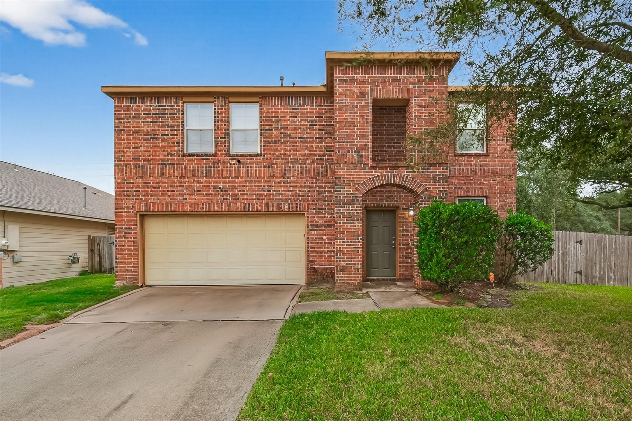 Image 1: This is a two-story brick home with a two-car gara