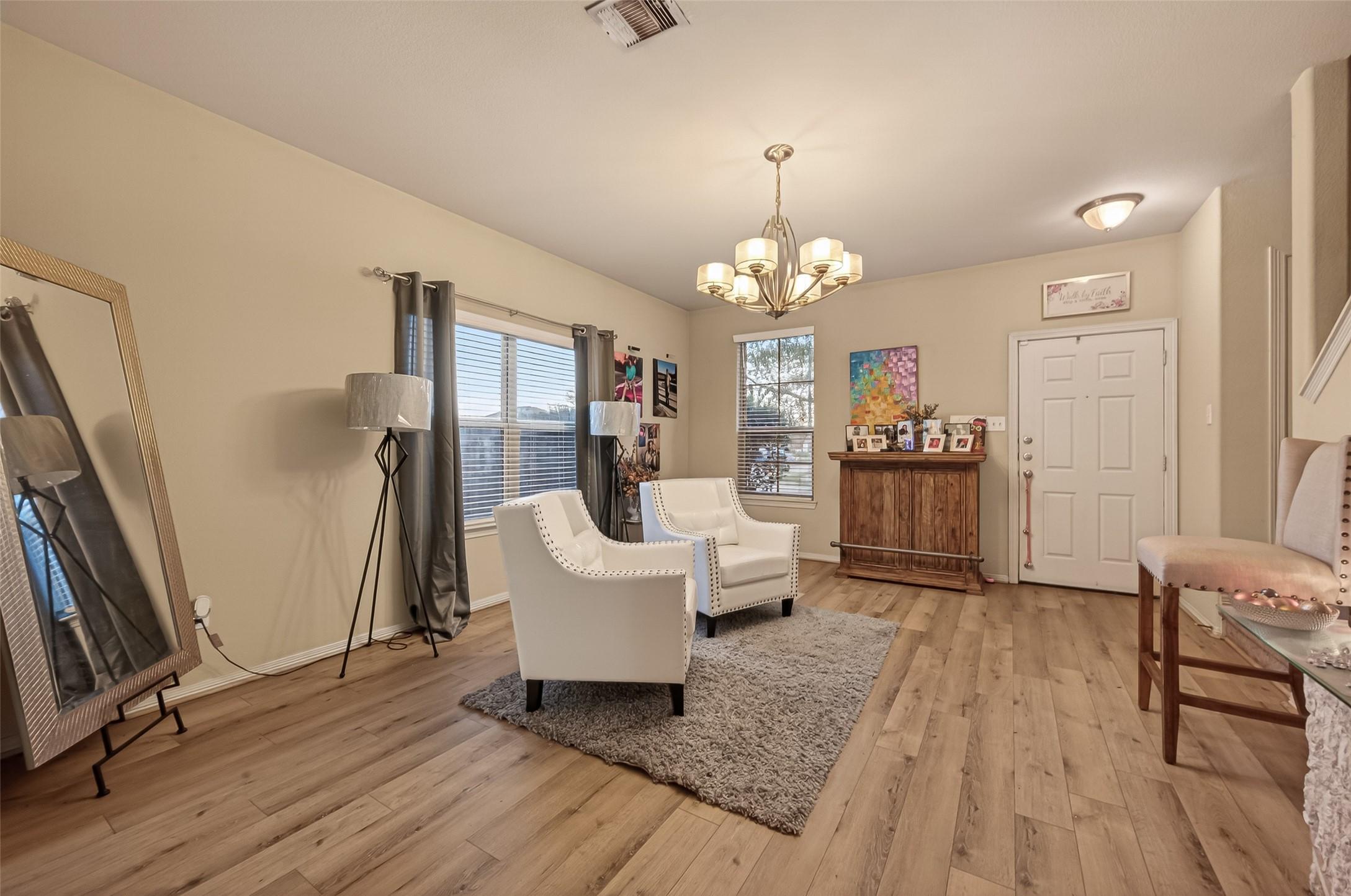 Image 2: Living area features hardwood floors, a stylish ch