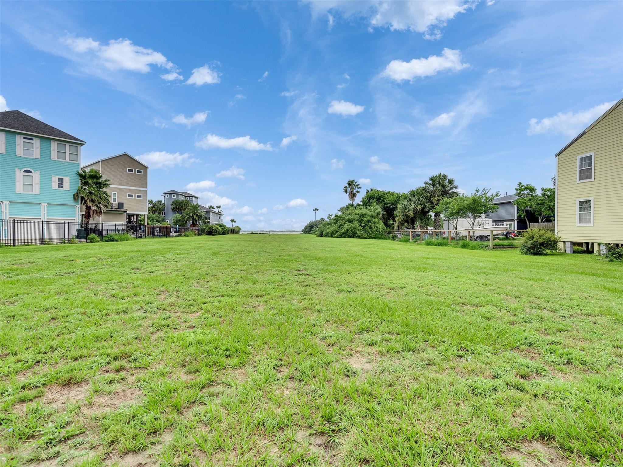 Image 2: This photo shows a spacious, grassy plot of land b