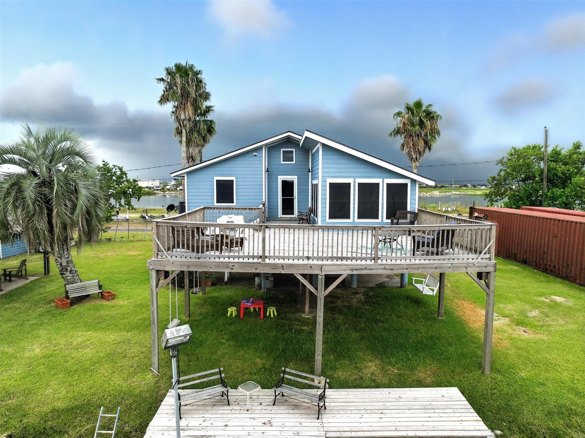 Image 1: View of rear of home with upper level deck and low