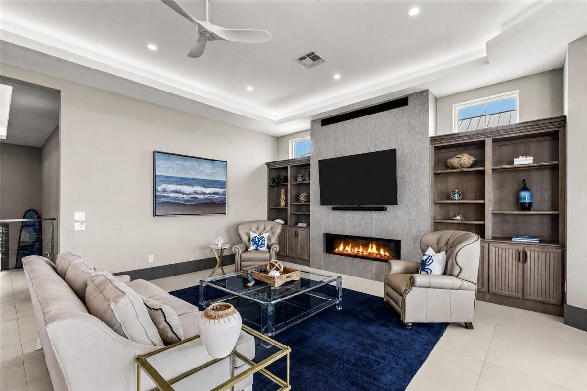 Image 4: This spacious living room features a sleek gas fir