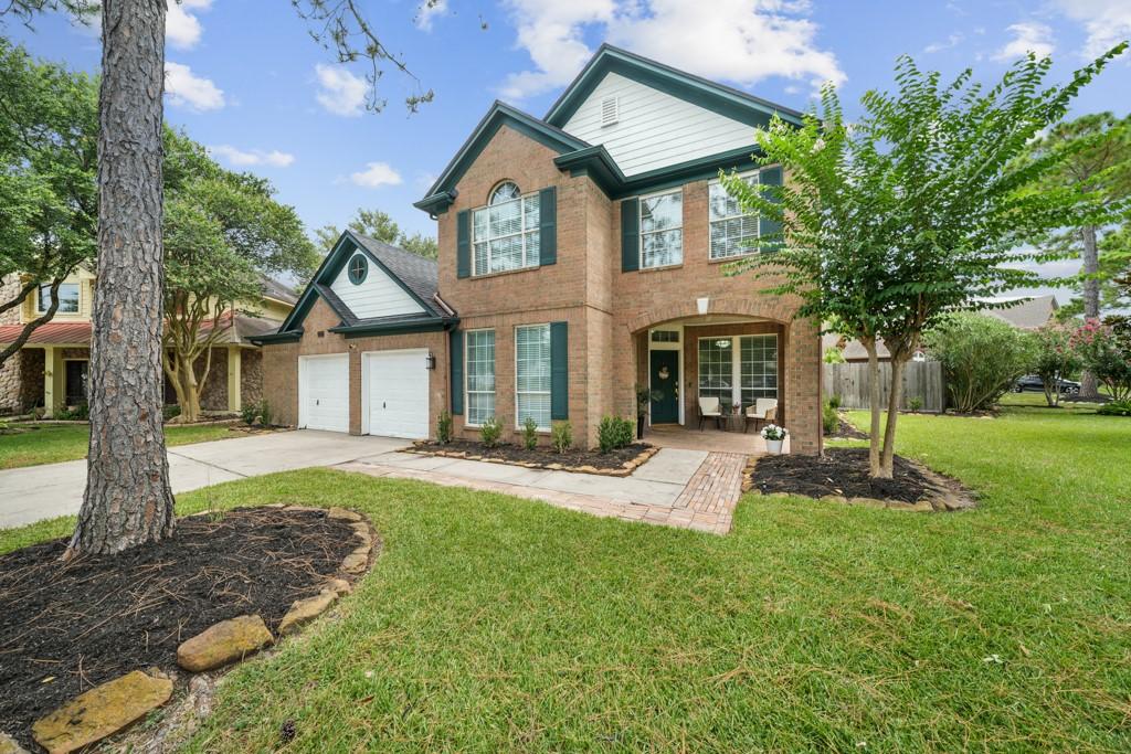 Image 1: Timeless curb appeal featuring lush landscaping, a