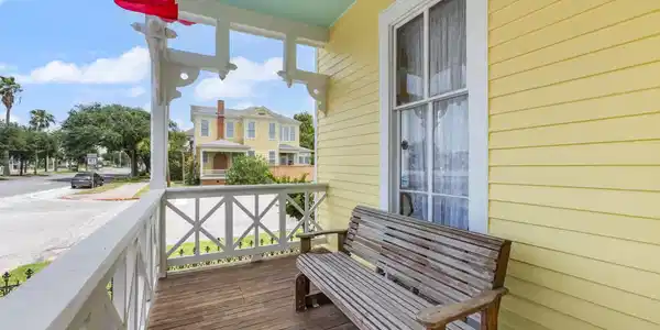 Image 2: The inviting covered porch features wood decking,