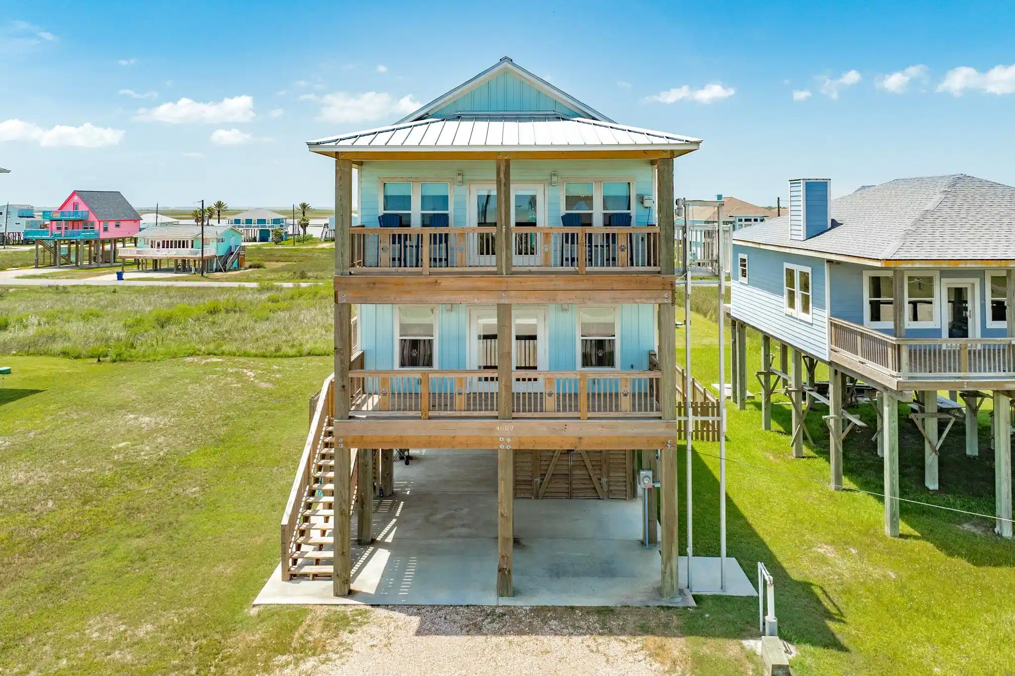 Image 1: Elevated coastal home with dual covered balconies,