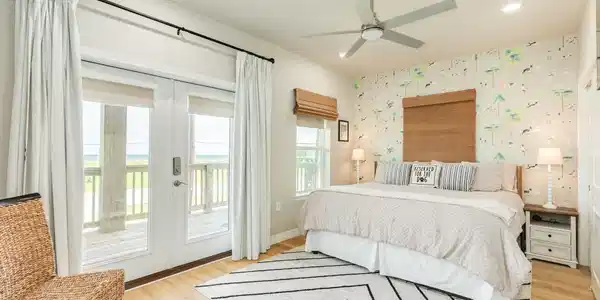 Image 4: Spacious primary bedroom features direct balcony a