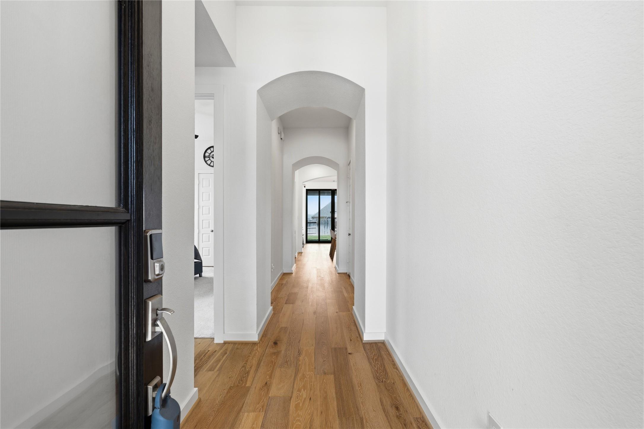 Image 2: Grand entry hallway with arched doorways and wood-