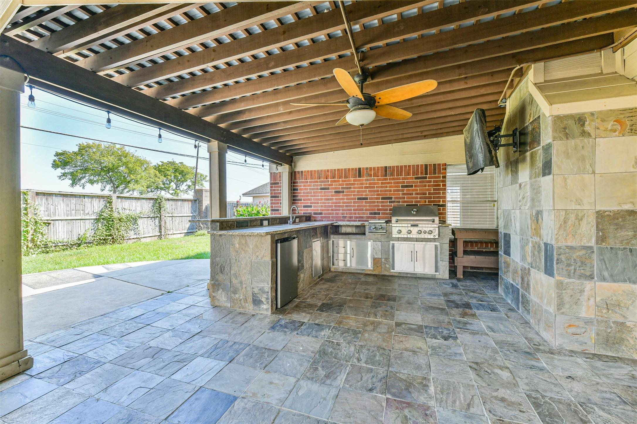 Image 3: Outdoor kitchen and tile flooring and a TV
