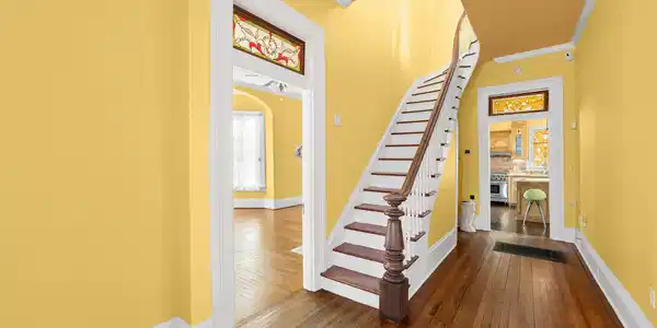 Image 4: A graceful curved staircase anchors the entry hall