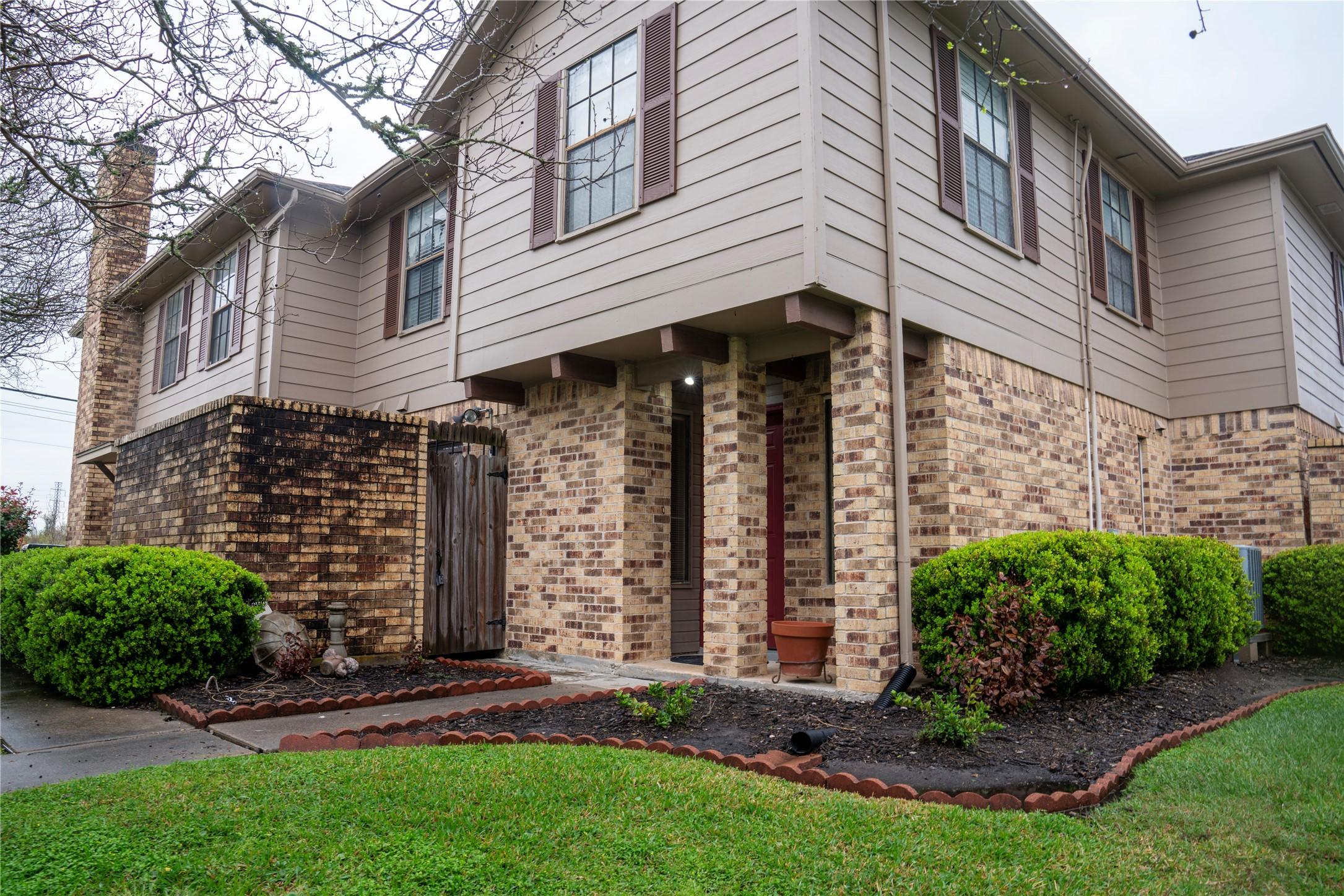 Image 2: This photo shows a two-story condo with brick and
