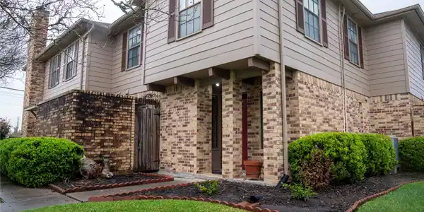 Image 2: This photo shows a two-story condo with brick and