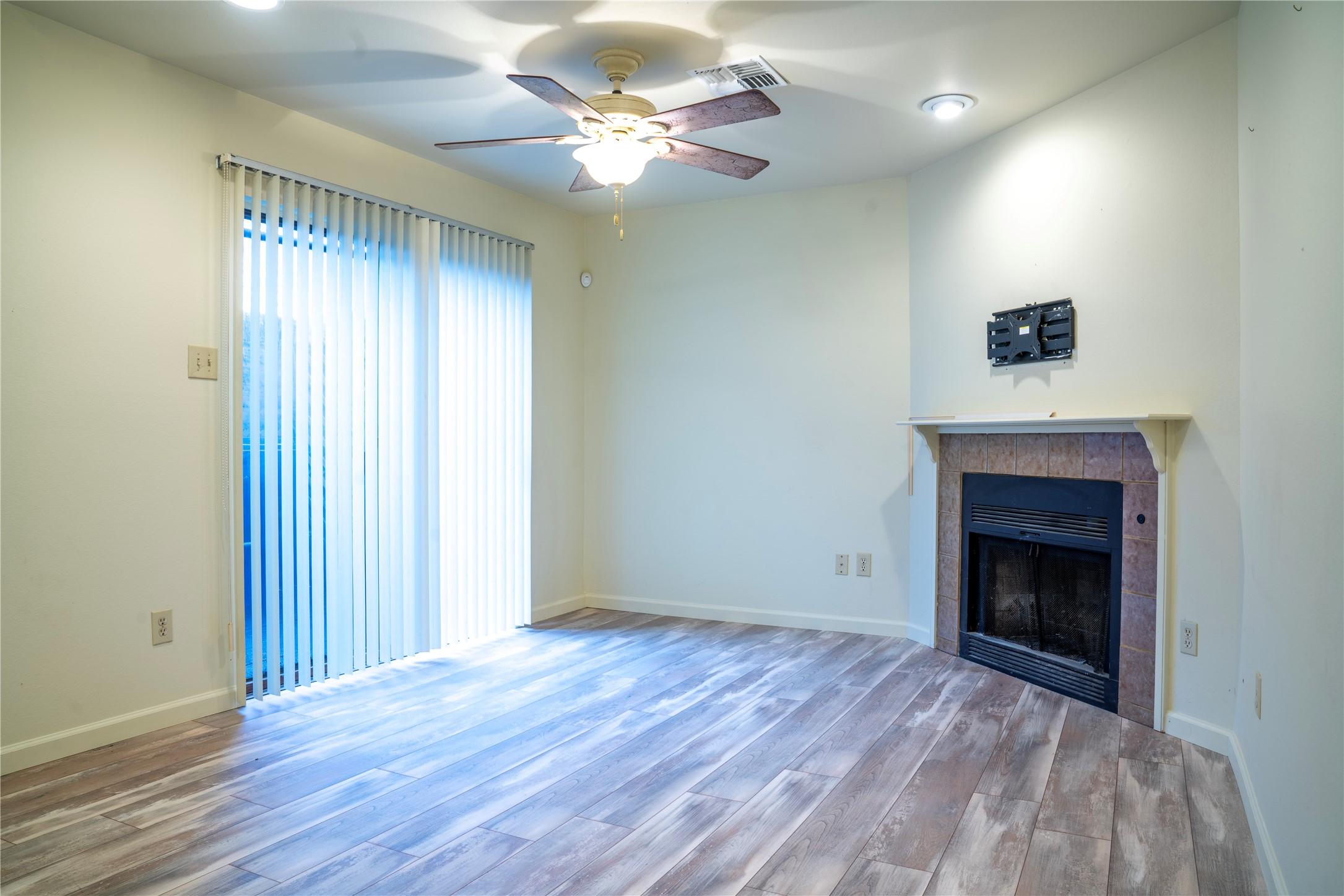 Image 3: Cozy living room featuring a ceiling fan, fireplac