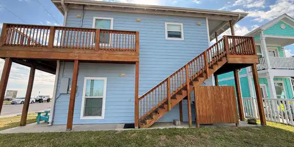 Image 2: This charming two-story home features a light blue