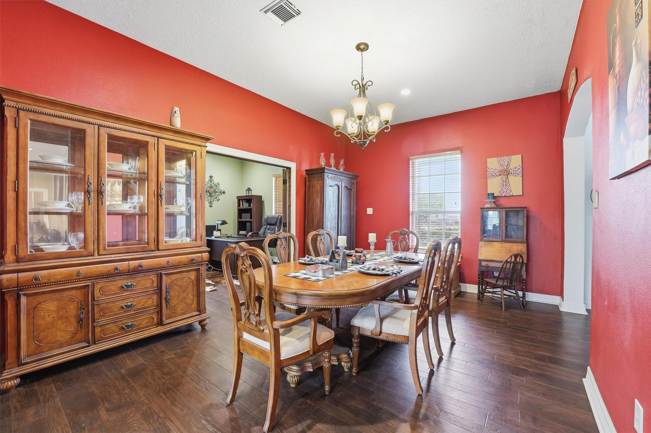 Image 4: Elegant formal dining room with bold color accents