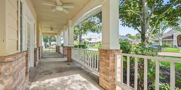 Image 2: Large covered porch with ceiling fans and charming