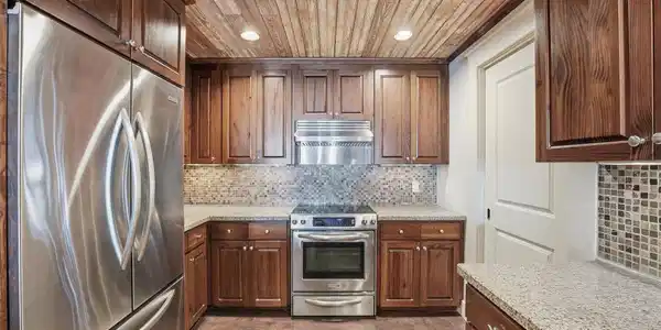 Image 4: The open-concept kitchen features rich wood cabine