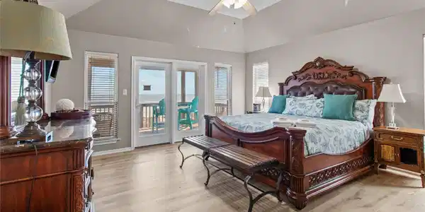 Image 2: This spacious bedroom features elegant wooden furn