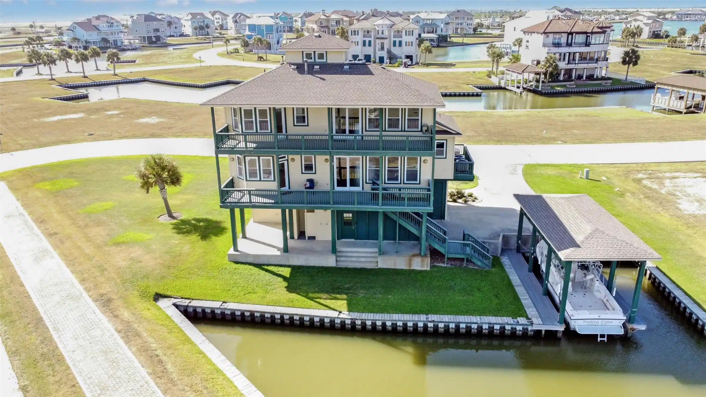 Image 1: Stunning areal view of this coastal home on canal