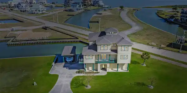 Image 4: Stunning areal view of this coastal home on canal